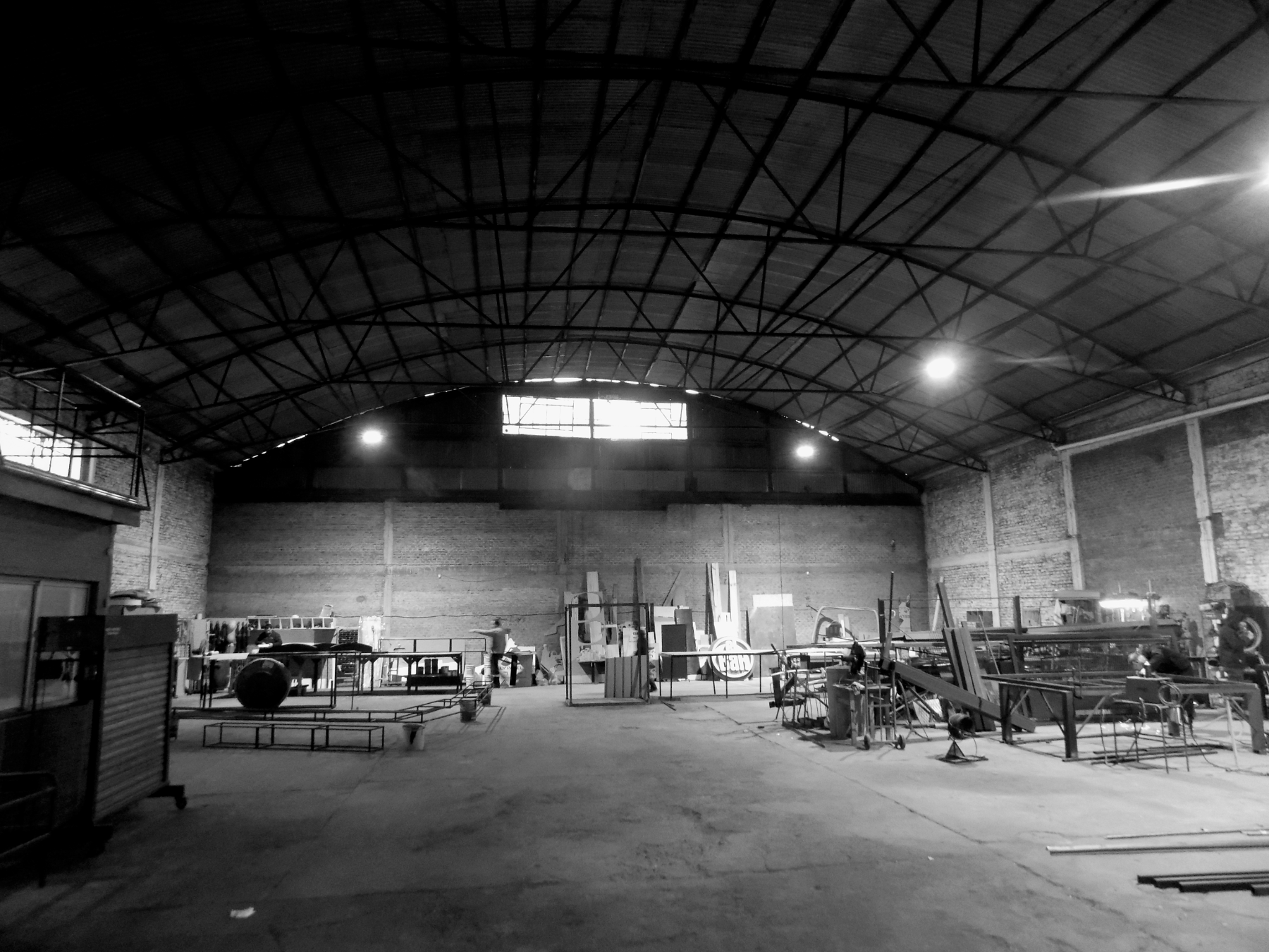 Two industrial workers collaborating in a factory setting, in black and white.
